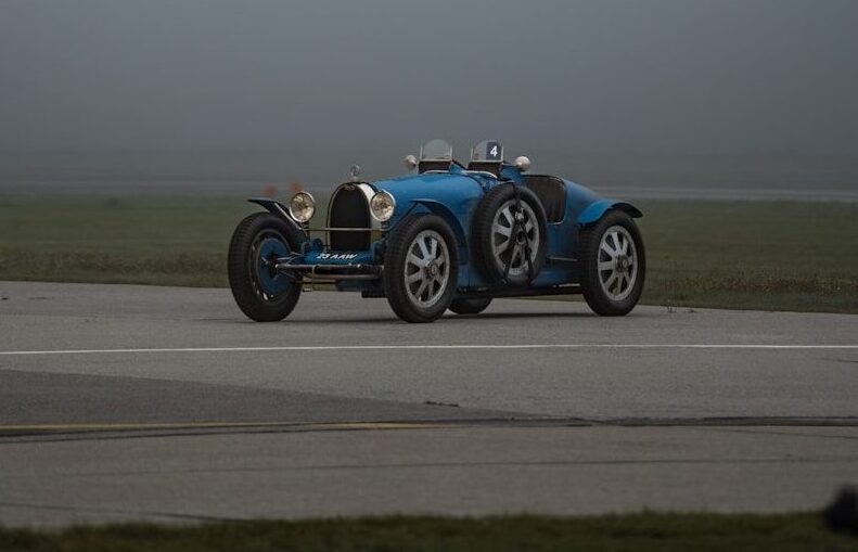 a blue race car driving down a runway