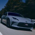 Updated 2026 Toyota GR86 in Solid Gray paint driving on a mountain road