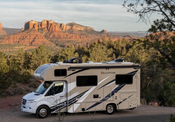 a white van parked on a road with trees and mountains in the background