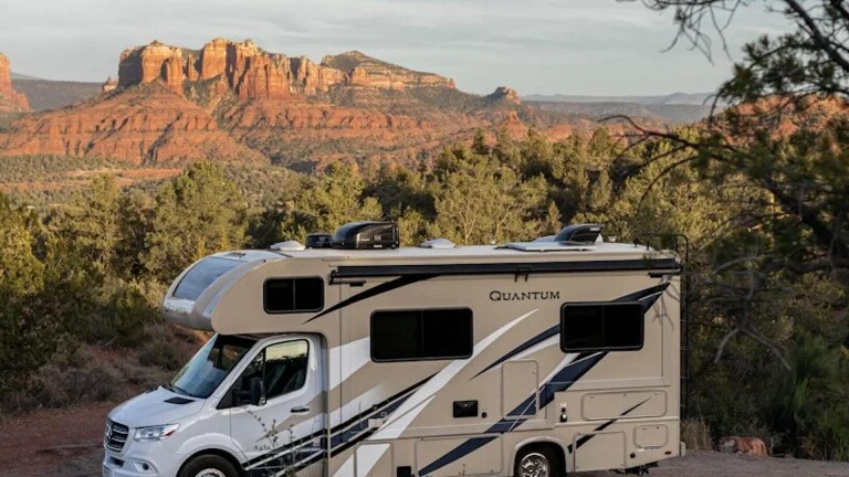 a white van parked on a road with trees and mountains in the background