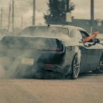 Black car doing a burnout with smoke billowing out
