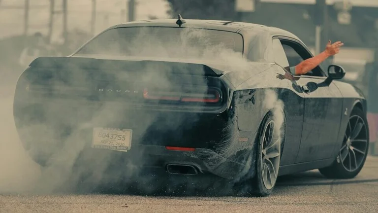Black car doing a burnout with smoke billowing out