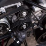 Close-up of a car engine bay showing belt and pulley system