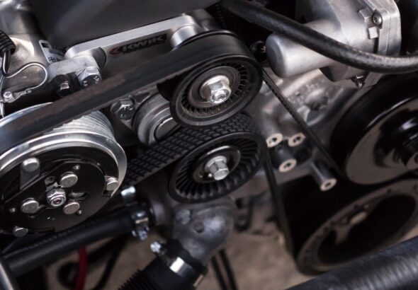 Close-up of a car engine bay showing belt and pulley system