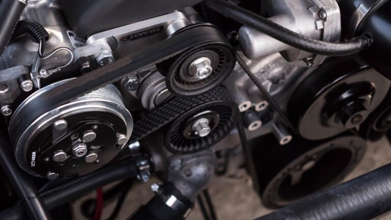 Close-up of a car engine bay showing belt and pulley system