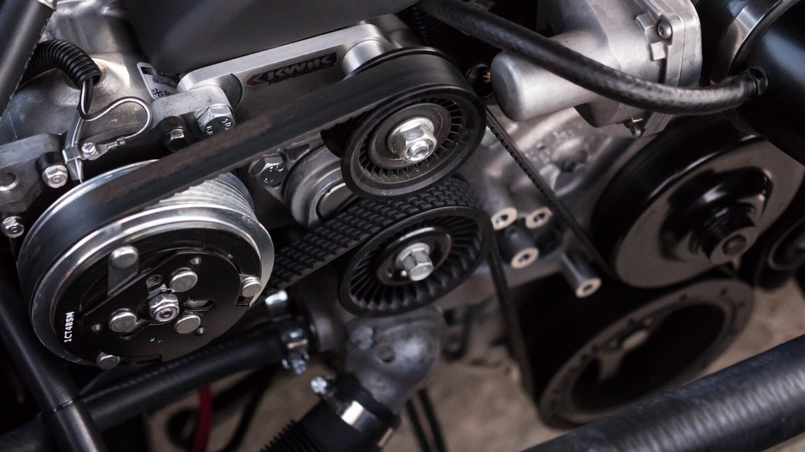 Close-up of a car engine bay showing belt and pulley system