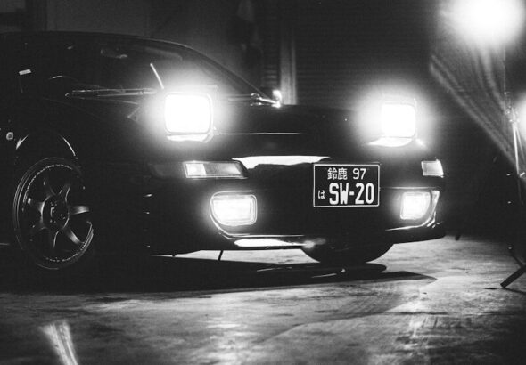Black sports car with headlights on at night