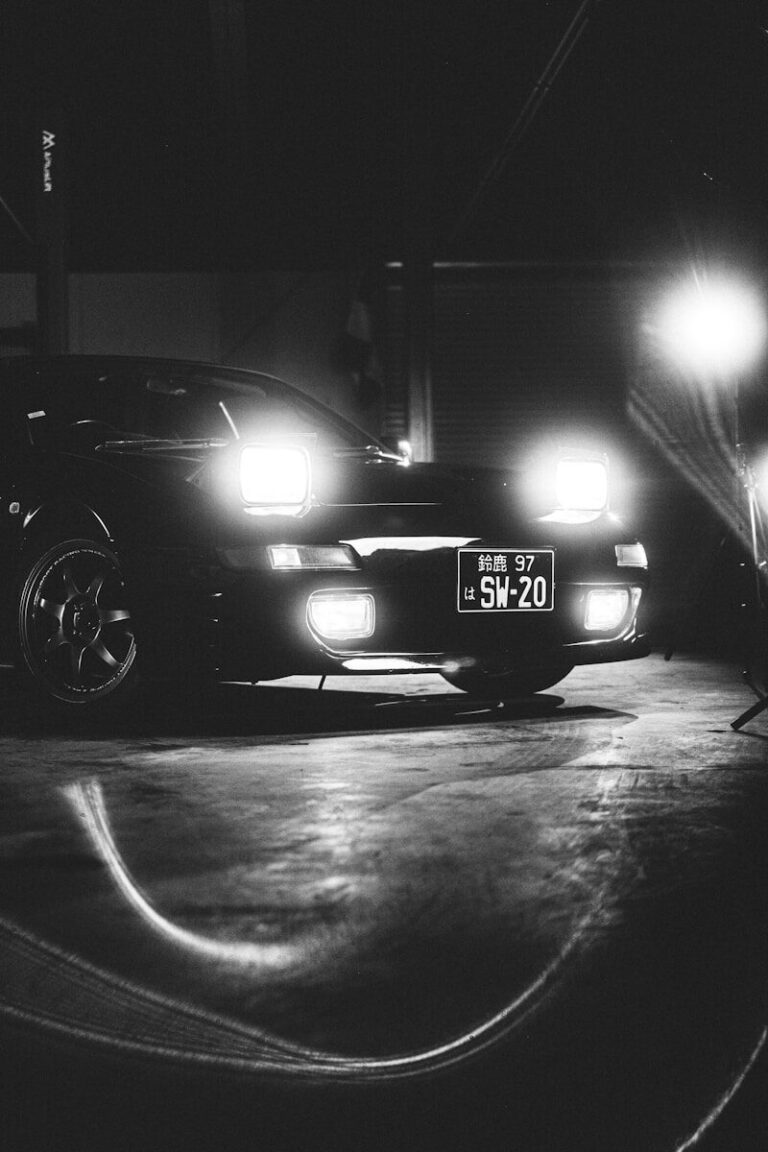 Black sports car with headlights on at night