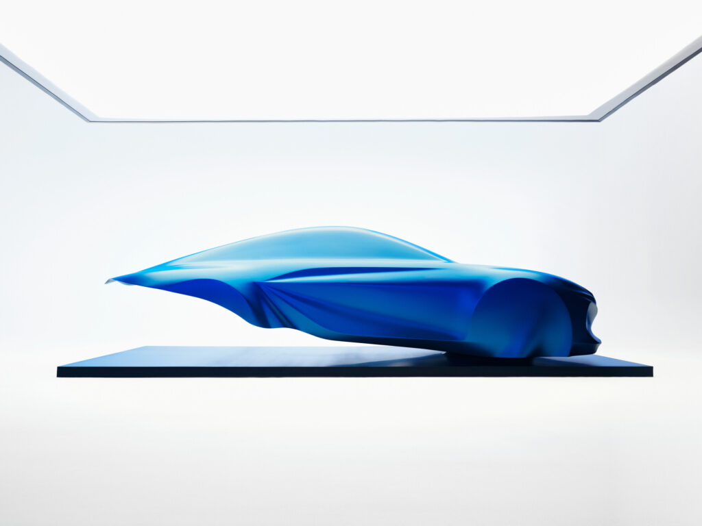 Side profile of the blue draped Alpine A110 sculpture