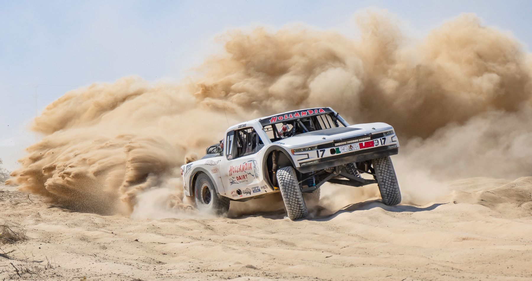Baja off-road race truck kicking up desert sand near Ensenada, Mexico