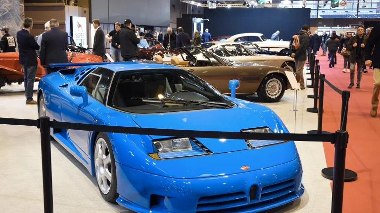 Blue Bugatti EB110 Super Sport displayed front three-quarter, showing its wedge nose, horseshoe grille and scissor-door greenhouse