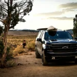 Black Chevrolet Silverado 1500 pickup parked on a dirt trail