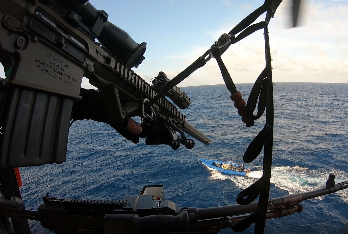 Coast Guard Helicopter Interdiction Tactical Squadron marksman aiming from a helicopter over the Atlantic Ocean