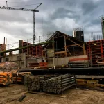 Construction site with a crane and formwork under a stormy sky