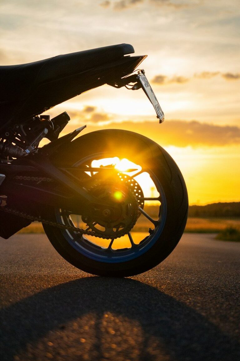 Motorcycle wheel at sunset with sun flare