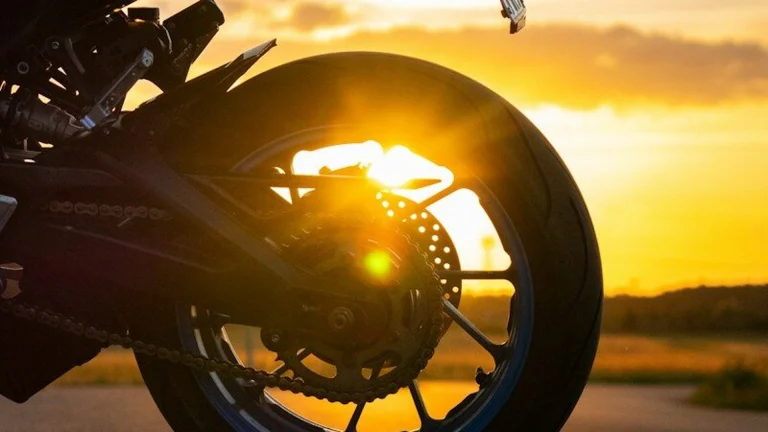 Motorcycle wheel at sunset with sun flare