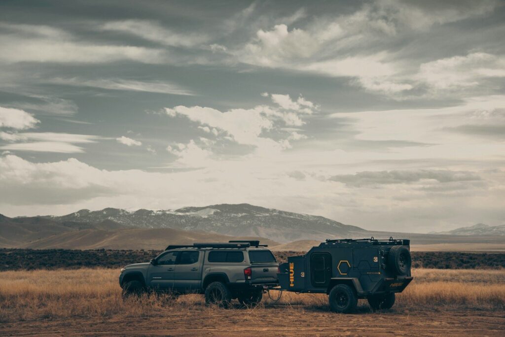 SUV towing an off-road camper trailer through open country