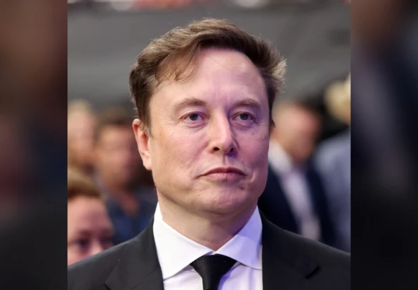 Elon Musk in a dark suit and tie