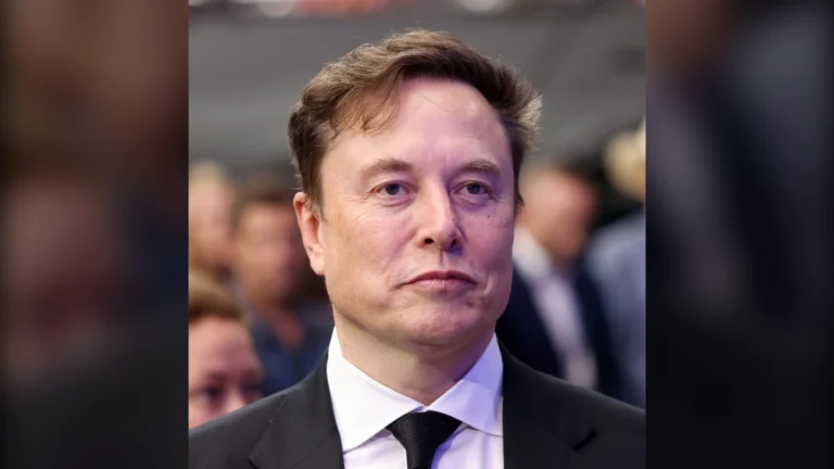 Elon Musk in a dark suit and tie