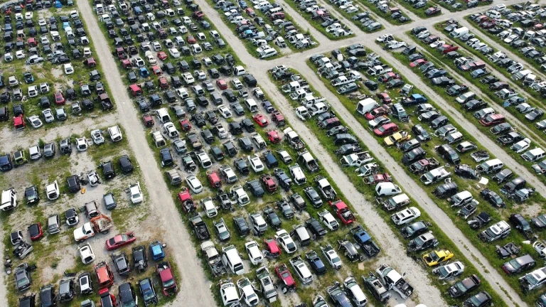 Aerial view of a large car junkyard with many vehicles