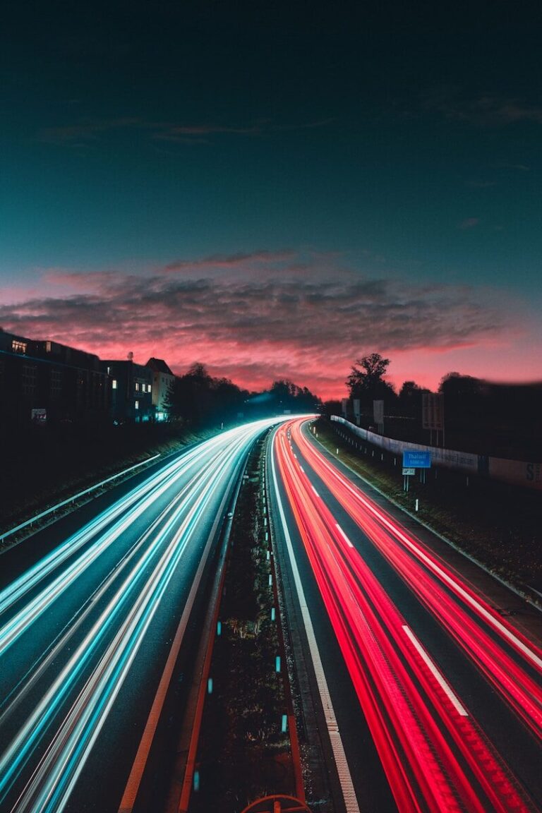 Long-exposure highway light trails at night, evoking red and blue emergency lighting