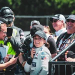 Jamie Chadwick smiling during a TV interview in the paddock