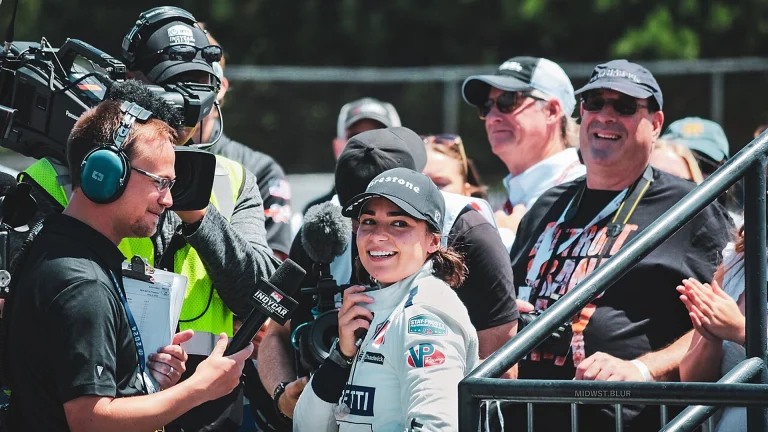 Jamie Chadwick smiling during a TV interview in the paddock