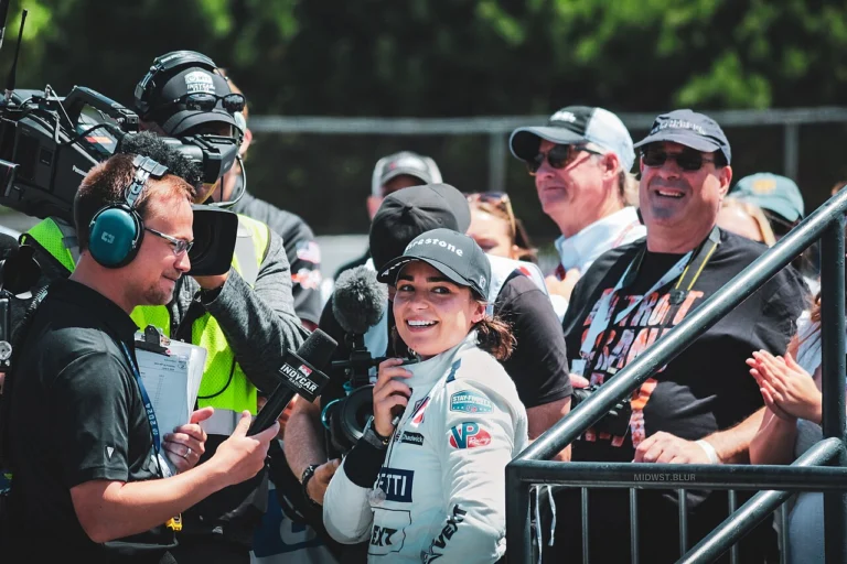 Jamie Chadwick smiling during a TV interview in the paddock