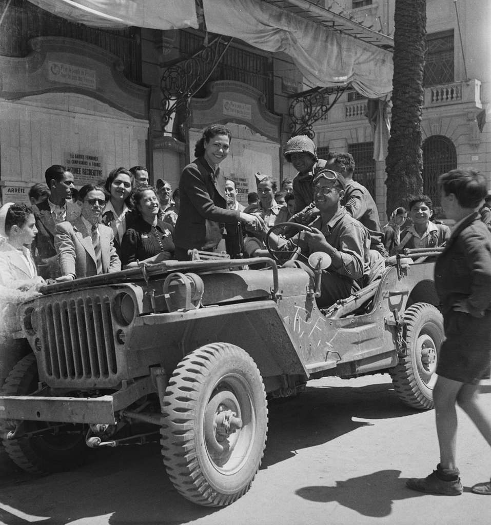 Local girls climbing onto U.S. Army jeeps in the streets of Tunis in 1943