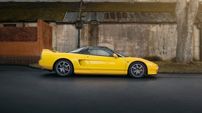 A yellow sports car parked in front of a building