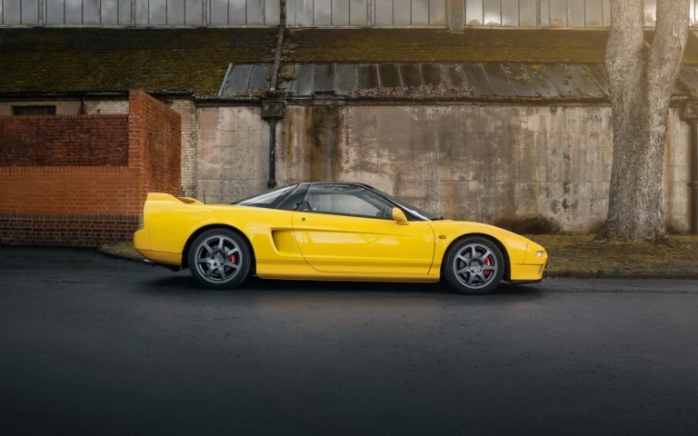 A yellow sports car parked in front of a building