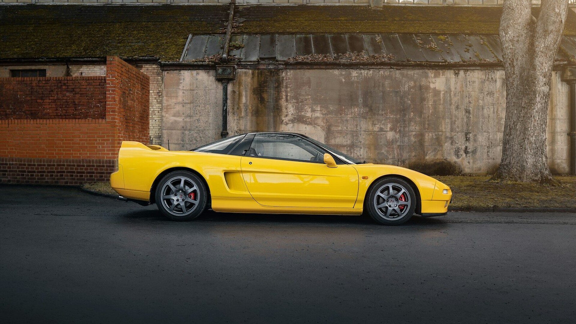 A yellow sports car parked in front of a building
