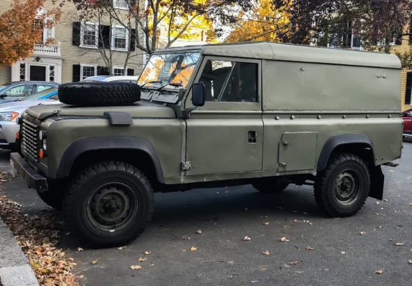Classic Land Rover Defender 110 hardtop parked on a US city street