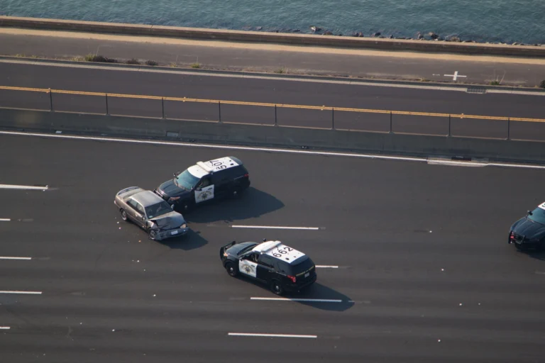 A patrol car uses a PIT maneuver to spin a fleeing vehicle on a highway