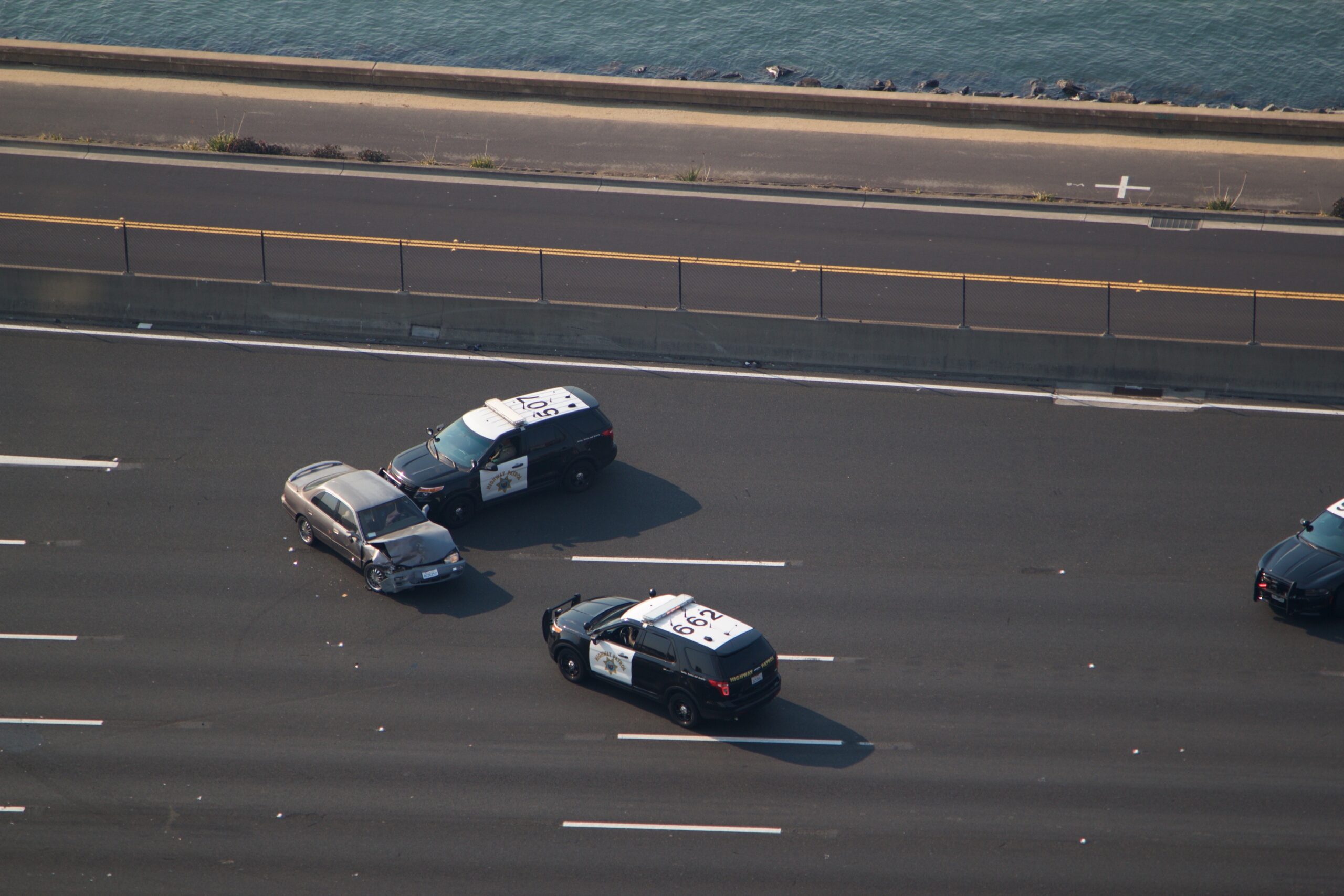 A patrol car uses a PIT maneuver to spin a fleeing vehicle on a highway