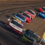 Race cars speeding around a sharp turn on a track