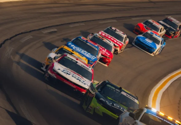 Race cars speeding around a sharp turn on a track