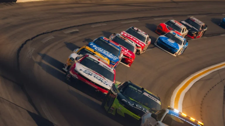 Race cars speeding around a sharp turn on a track