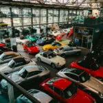 Rows of classic and collector cars parked inside a large private collection warehouse