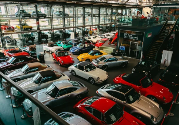 Rows of classic and collector cars parked inside a large private collection warehouse