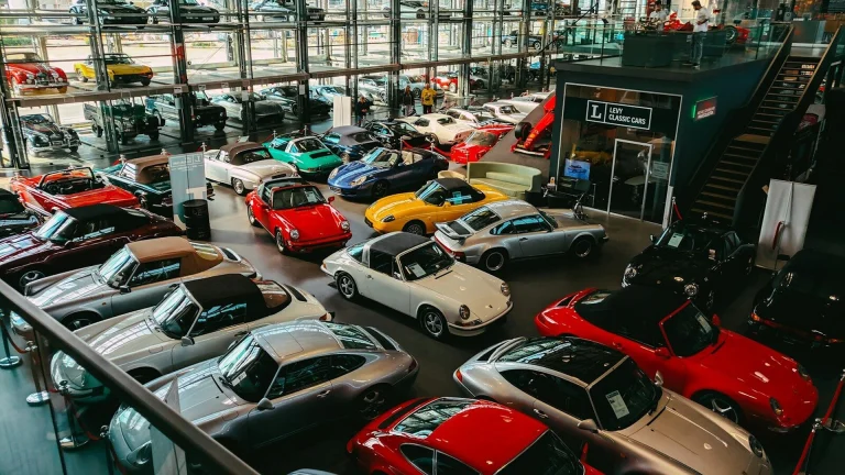 Rows of classic and collector cars parked inside a large private collection warehouse