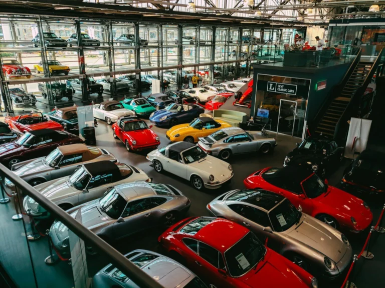 Rows of classic and collector cars parked inside a large private collection warehouse