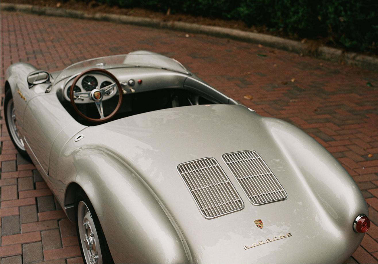Overhead rear three-quarter view of the Porsche 550 J showing twin rear deck grilles and wood-rimmed steering wheel