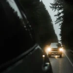Headlights of a following car reflected in a rearview mirror at night