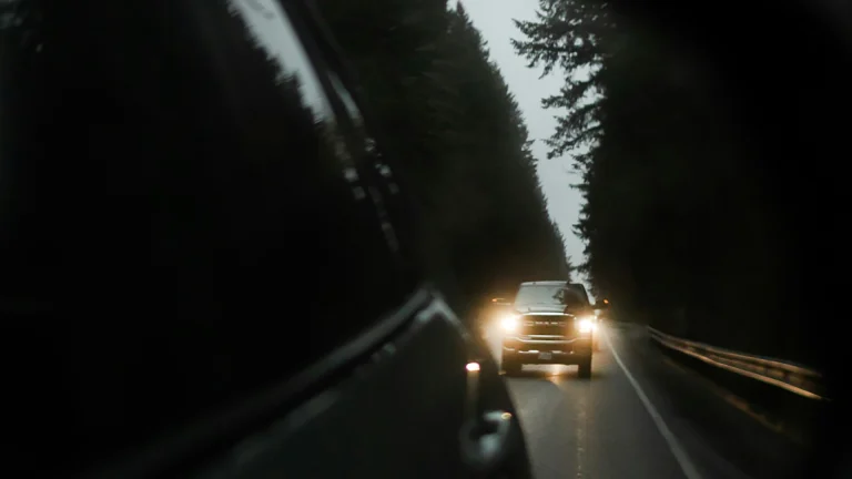 Headlights of a following car reflected in a rearview mirror at night