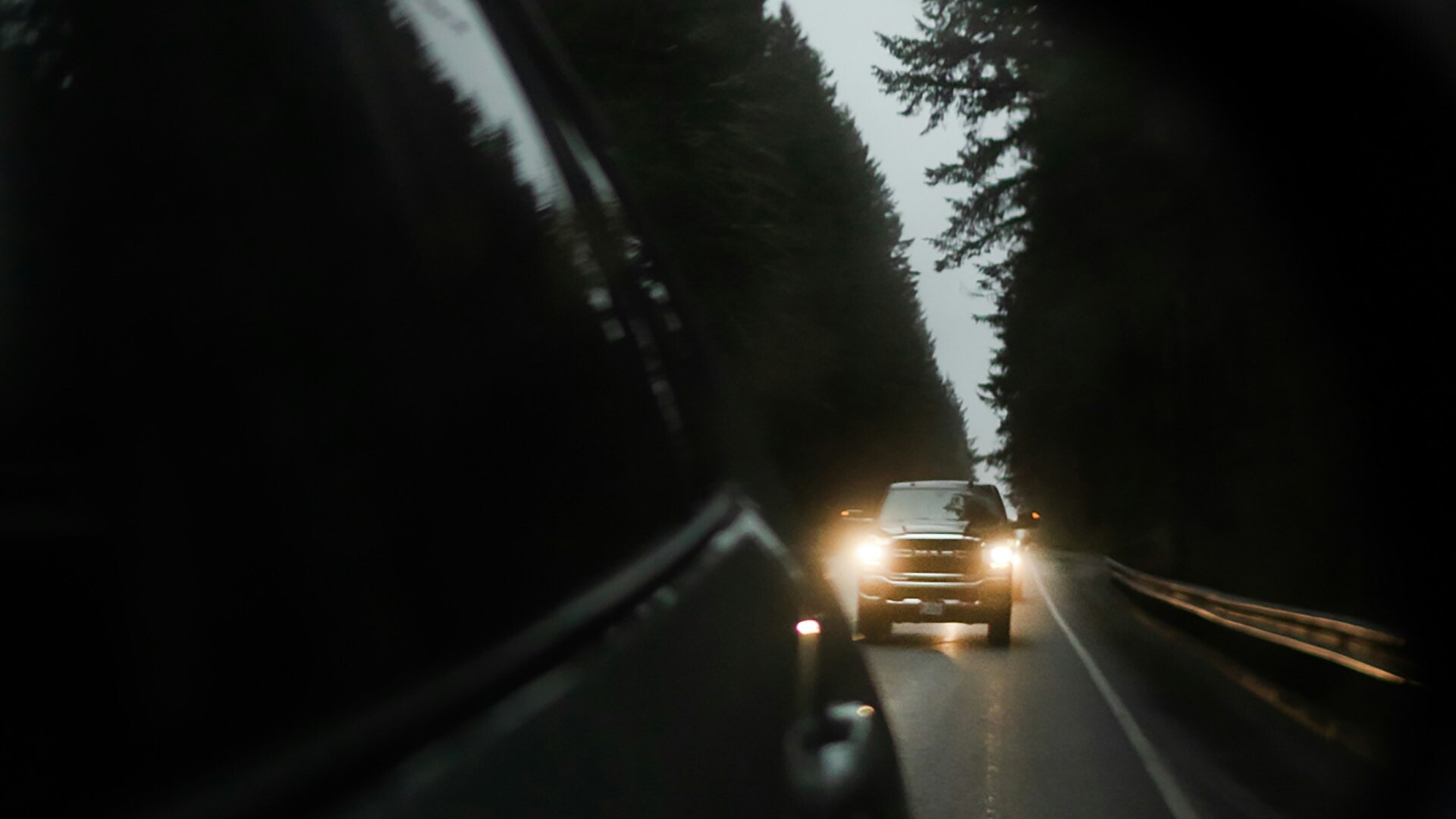 Headlights of a following car reflected in a rearview mirror at night