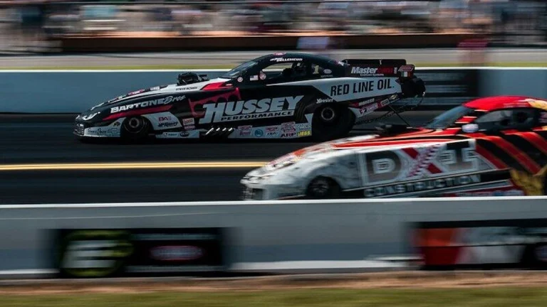 time-lapse photography of cars passing in a race track