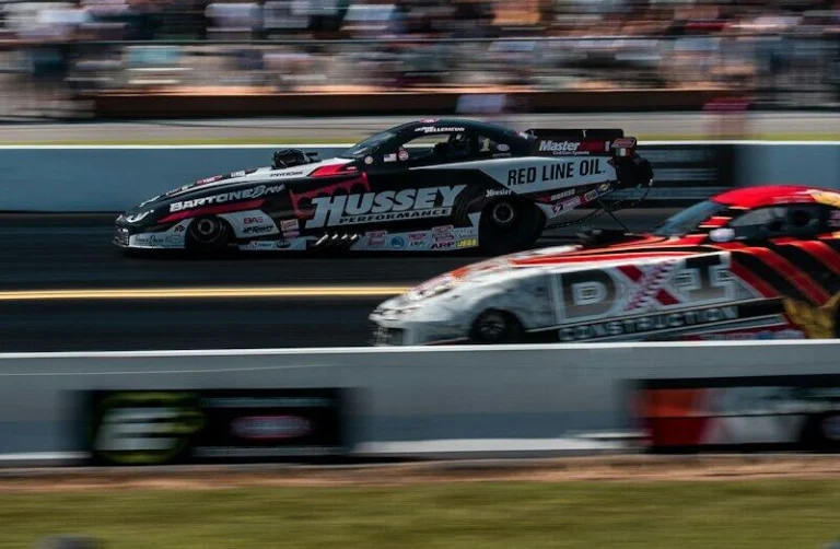 time-lapse photography of cars passing in a race track