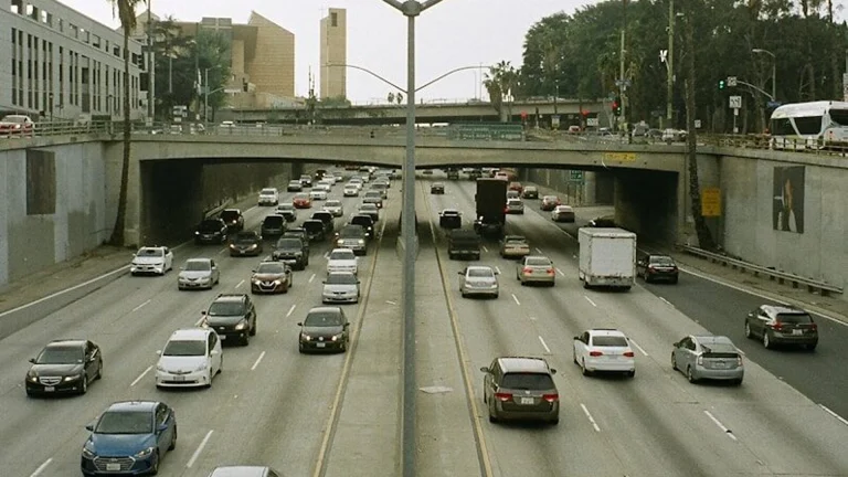 Traffic backed up on a Los Angeles freeway under a hazy, smog-filled sky