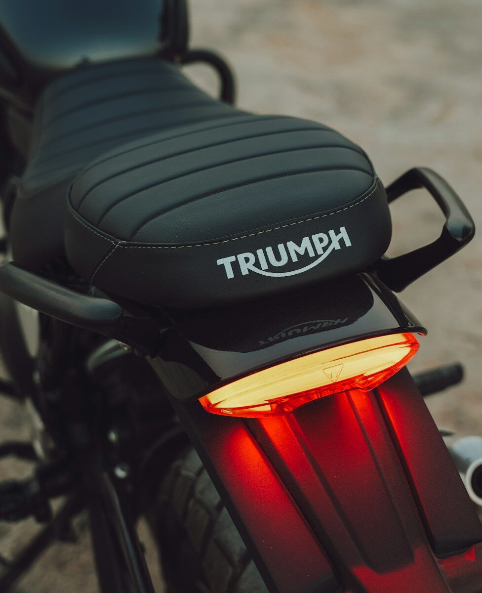 Black motorcycle seat with triumph logo and brake light